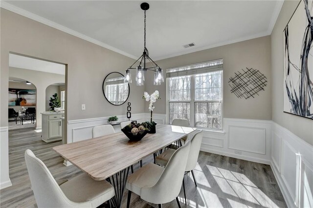 kitchen with a kitchen island, appliances with stainless steel finishes, pendant lighting, white cabinetry, and sink