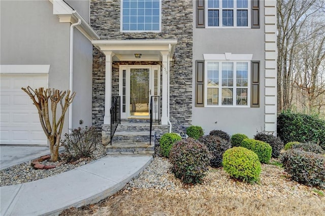 view of exterior entry with stone siding, an attached garage, and stucco siding