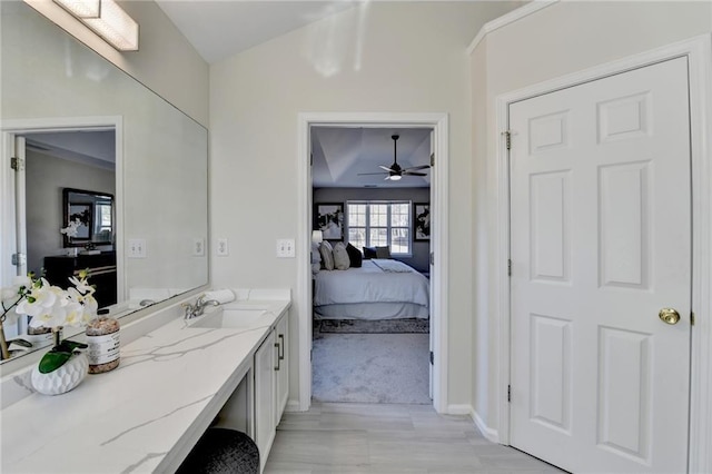 ensuite bathroom with lofted ceiling, ensuite bath, and vanity