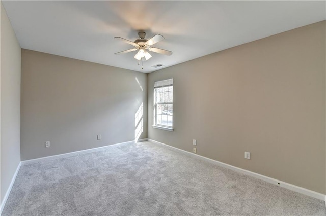 empty room with ceiling fan, carpet flooring, visible vents, and baseboards