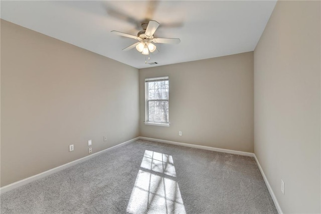 carpeted empty room with ceiling fan, visible vents, and baseboards