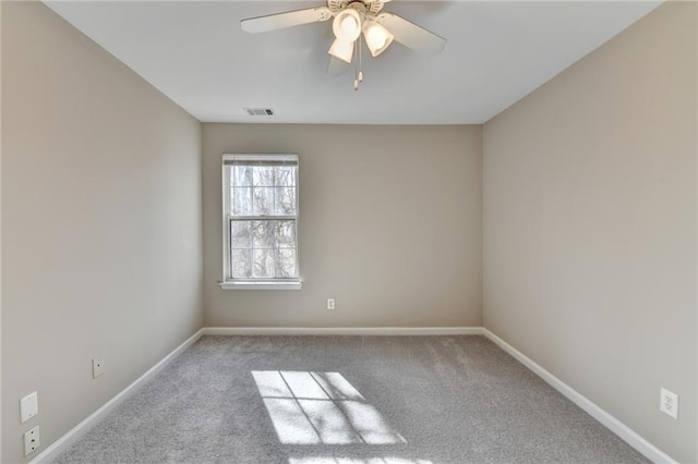 spare room featuring a ceiling fan, carpet, visible vents, and baseboards