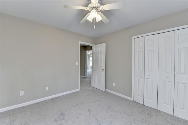 unfurnished bedroom featuring carpet floors, a closet, baseboards, and a ceiling fan