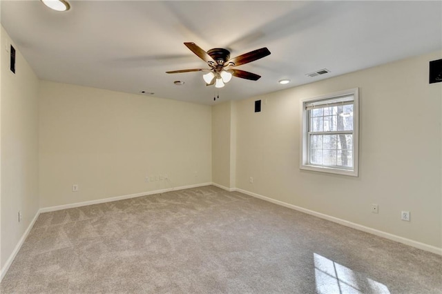 carpeted empty room with visible vents, ceiling fan, and baseboards