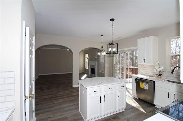 unfurnished bedroom with light carpet, ensuite bath, a tray ceiling, and ceiling fan