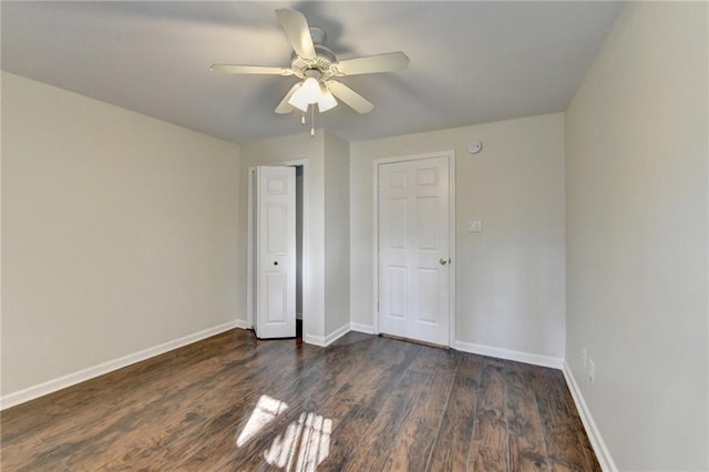 unfurnished bedroom with dark wood-style flooring, a closet, a ceiling fan, and baseboards