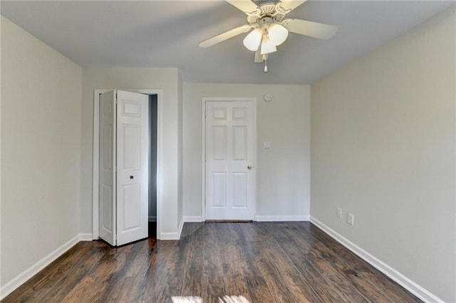 unfurnished bedroom with a closet, dark wood finished floors, a ceiling fan, and baseboards