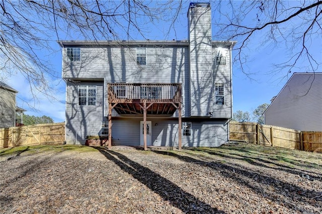 rear view of house featuring a fenced backyard, a chimney, and a deck