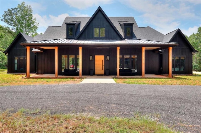 3960 Stock Rd, Monroe, GA 30656 - view of front of house with a standing seam roof, covered porch, roof with shingles, and a metal roof