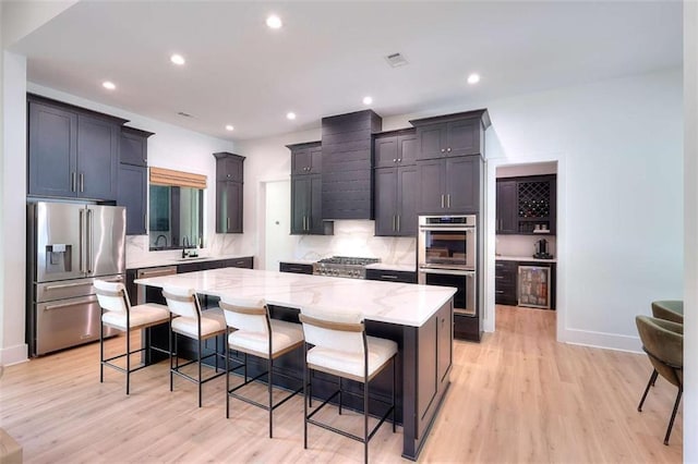 3960 Stock Rd, Monroe, GA 30656 - kitchen with stainless steel appliances, light stone counters, a large island, light wood-style flooring, and recessed lighting