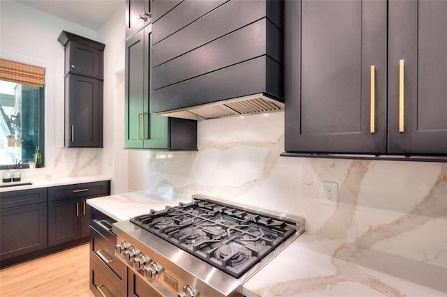 3960 Stock Rd, Monroe, GA 30656 - kitchen with stainless steel gas stovetop, premium range hood, tasteful backsplash, and light stone counters