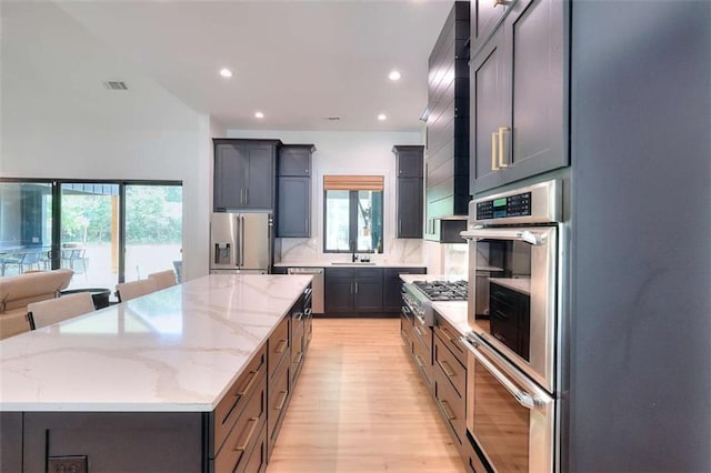 3960 Stock Rd, Monroe, GA 30656 - kitchen with appliances with stainless steel finishes, a spacious island, light wood finished floors, recessed lighting, and light stone counters