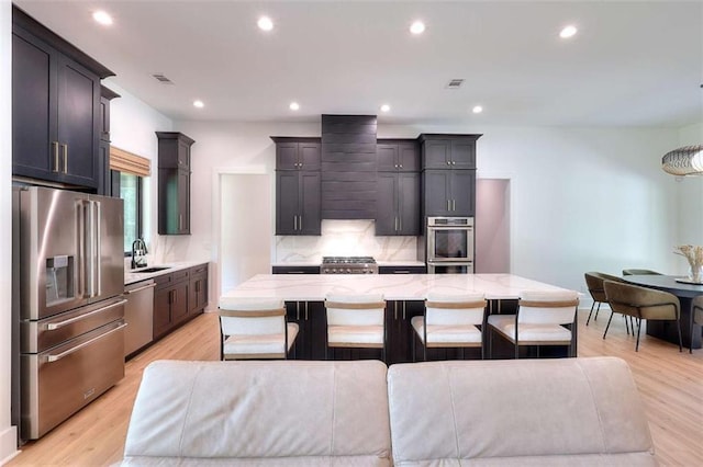 3960 Stock Rd, Monroe, GA 30656 - kitchen featuring stainless steel appliances, wall chimney range hood, backsplash, light stone counters, and a large island