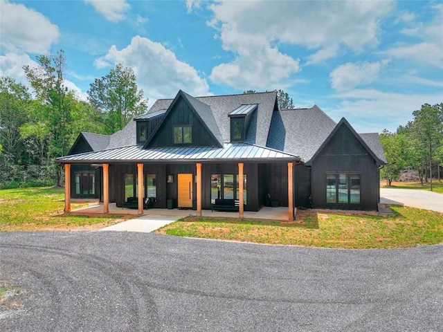 3960 Stock Rd, Monroe, GA 30656 - modern farmhouse featuring a standing seam roof, a porch, a shingled roof, and a metal roof