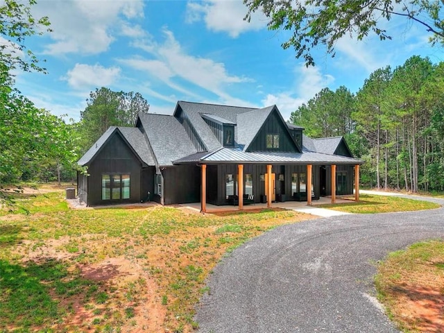 3960 Stock Rd, Monroe, GA 30656 - modern farmhouse featuring a standing seam roof, covered porch, a metal roof, and board and batten siding