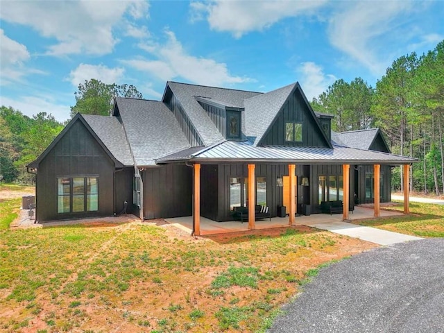 3960 Stock Rd, Monroe, GA 30656 - rear view of property with a standing seam roof, a shingled roof, board and batten siding, a metal roof, and a yard