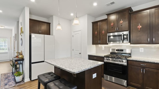 305 Knights Ct, Canton, GA 30115 - kitchen with appliances with stainless steel finishes, visible vents, dark brown cabinets, a center island, and wood finished floors
