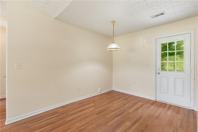 131 Tye St, Stockbridge, GA 30281 - unfurnished dining area with light wood-style floors, baseboards, and a textured ceiling