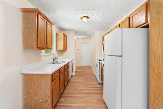 131 Tye St, Stockbridge, GA 30281 - kitchen with white appliances, a sink, light wood-style floors, light countertops, and brown cabinetry