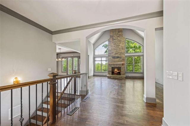 hall with a notable chandelier, dark wood-type flooring, crown molding, and vaulted ceiling