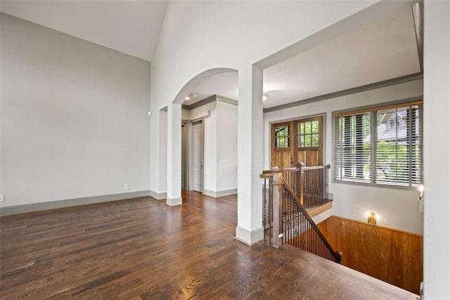 unfurnished room with crown molding, dark wood-type flooring, and vaulted ceiling