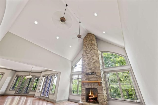 living room with high vaulted ceiling, a stone fireplace, and ceiling fan