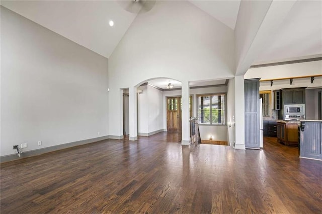 unfurnished living room with dark hardwood / wood-style floors and high vaulted ceiling