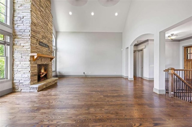 unfurnished living room featuring a wealth of natural light, a fireplace, and high vaulted ceiling