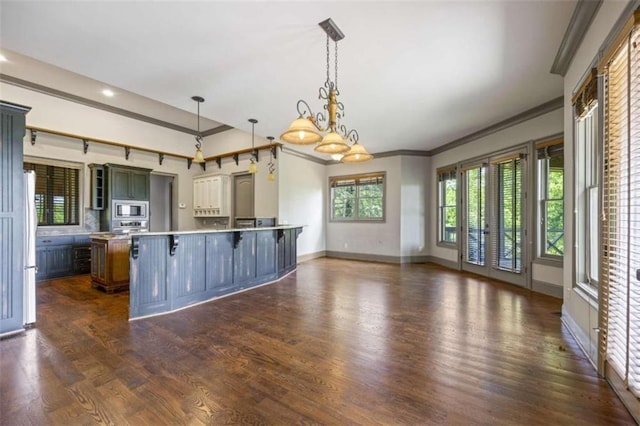 kitchen with a kitchen bar, built in microwave, pendant lighting, an inviting chandelier, and white fridge