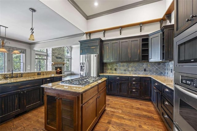 kitchen featuring hanging light fixtures, dark brown cabinets, a center island, and stainless steel appliances