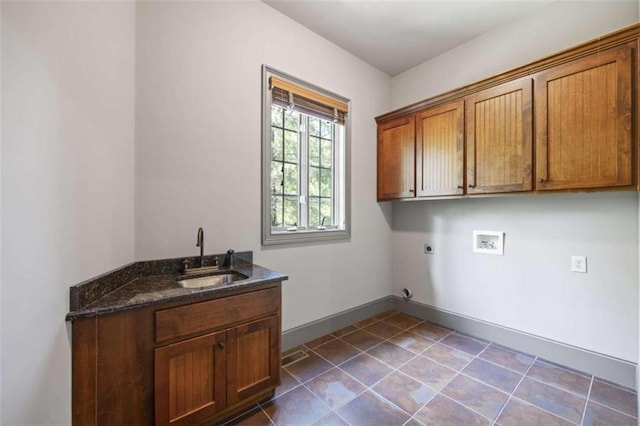 clothes washing area with cabinets, washer hookup, electric dryer hookup, sink, and dark tile patterned flooring