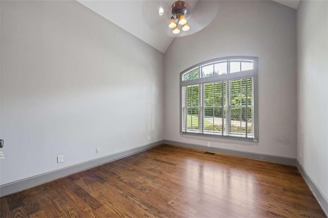 spare room featuring ceiling fan, dark wood-type flooring, and vaulted ceiling