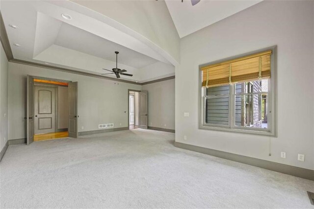 interior space with a raised ceiling and ceiling fan