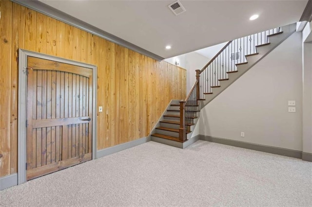 interior space featuring carpet flooring and wood walls