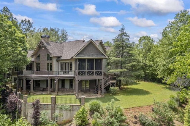 back of house featuring a lawn, a wooden deck, and a sunroom