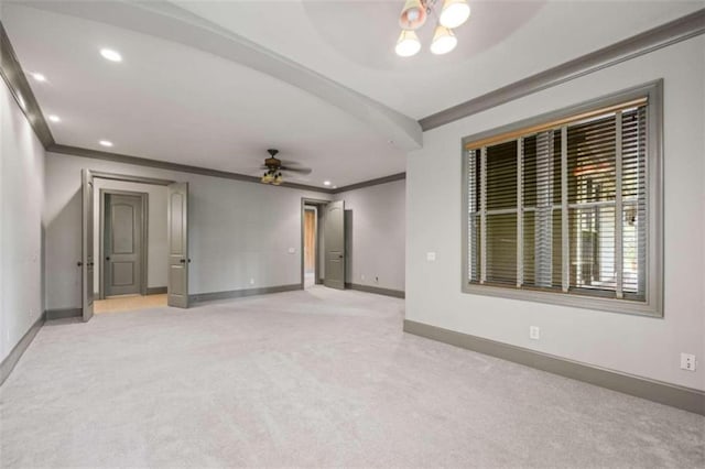 carpeted spare room featuring ceiling fan with notable chandelier and crown molding