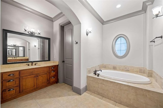 bathroom with tile patterned flooring, vanity, crown molding, and tiled bath