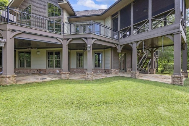 rear view of property featuring a lawn, ceiling fan, and a patio area