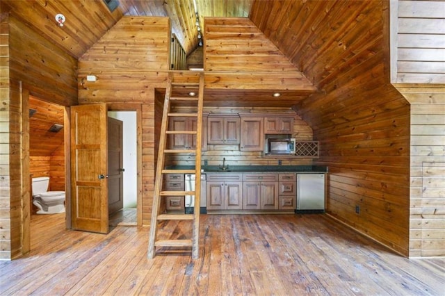 kitchen featuring hardwood / wood-style floors, wood walls, wooden ceiling, and high vaulted ceiling