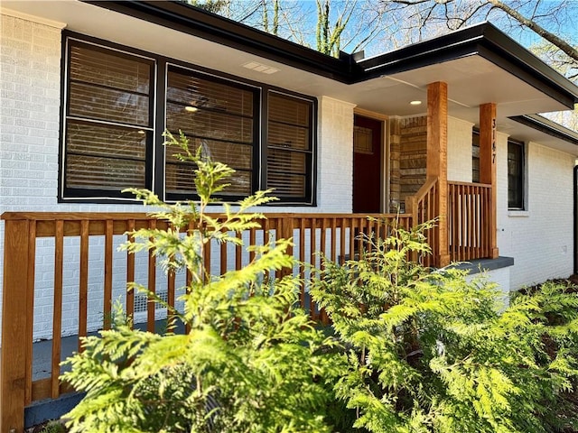 view of property exterior featuring covered porch and brick siding