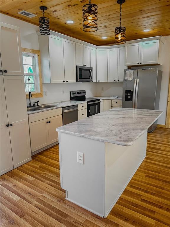 kitchen with wood ceiling, sink, appliances with stainless steel finishes, and light wood-type flooring