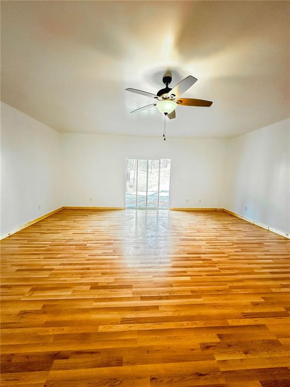 unfurnished room featuring light wood-type flooring and ceiling fan