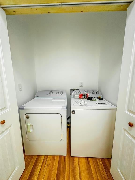 clothes washing area with light wood-type flooring and independent washer and dryer