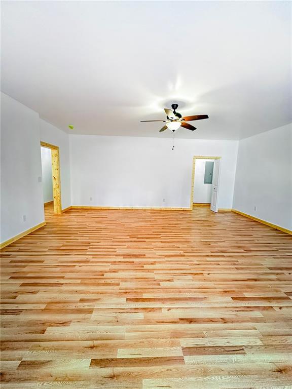 unfurnished living room with light wood-type flooring and ceiling fan