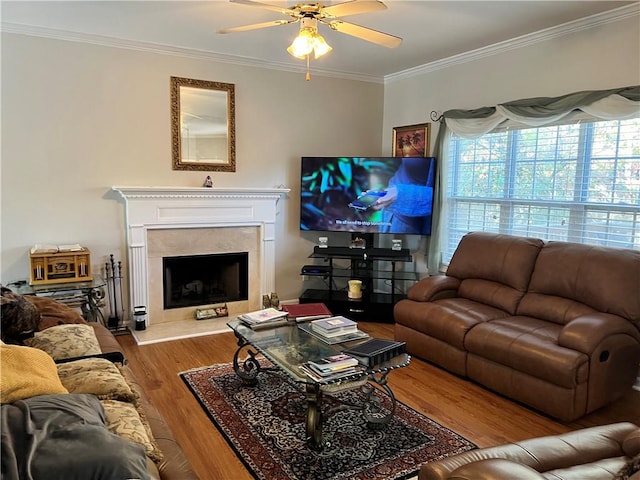 living room with light hardwood / wood-style floors, ceiling fan, and ornamental molding