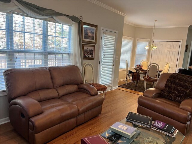 living room featuring ceiling fan, ornamental molding, and light wood-type flooring