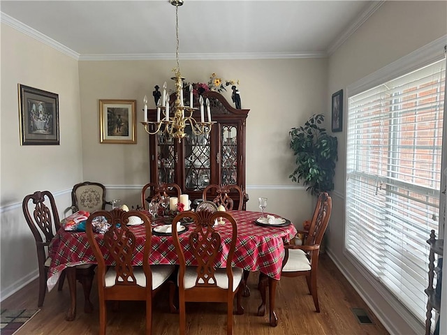 dining space featuring a chandelier, crown molding, and wood-type flooring