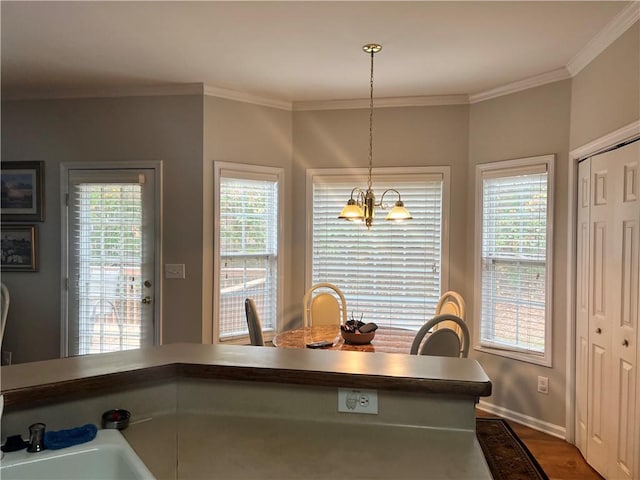 kitchen with decorative light fixtures, an inviting chandelier, plenty of natural light, and crown molding