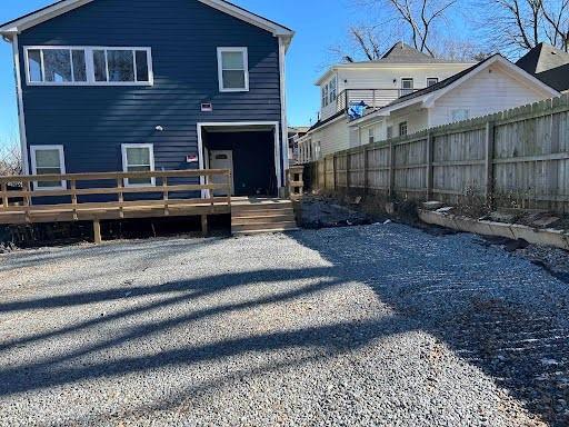 back of house featuring fence and a wooden deck