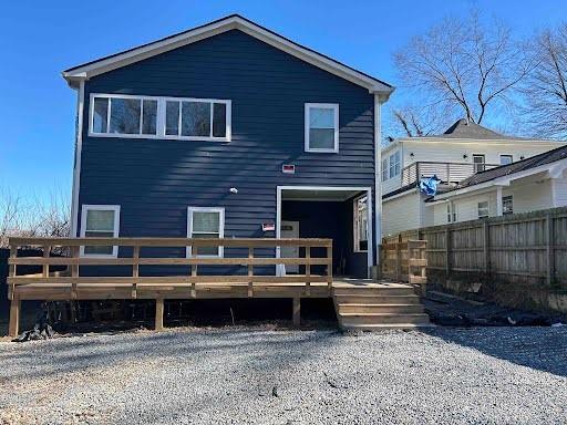 rear view of property featuring fence and a deck